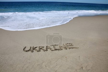 Téléchargez les photos : Ukraine written in the sand on the beach.  message handwritten on a smooth sand beach - en image libre de droit