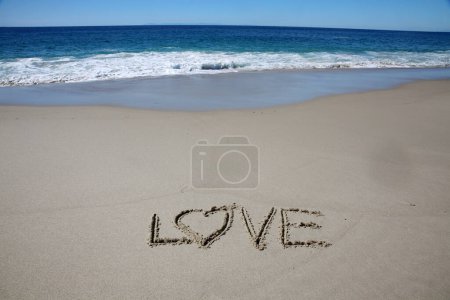 Téléchargez les photos : Love written in the sand on the beach.  message handwritten on a smooth sand beach - en image libre de droit