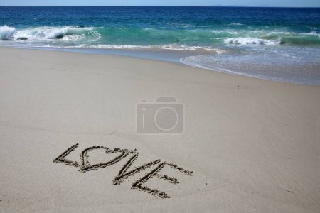Foto de Written in the sand on the beach.  message handwritten on a smooth sand beach - Imagen libre de derechos