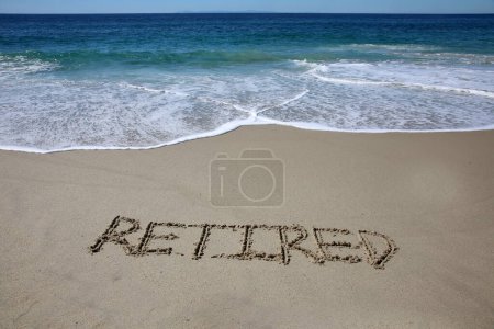 Téléchargez les photos : Retired  written in the sand on the beach.  message handwritten on a smooth sand beach - en image libre de droit