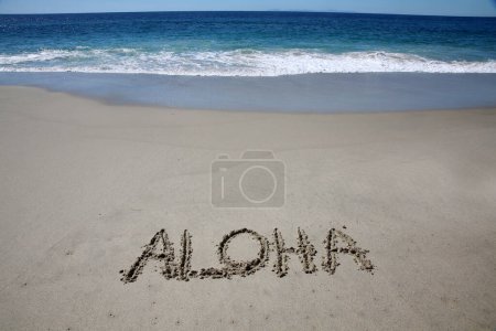 Téléchargez les photos : Aloha written in the sand on the beach.  message handwritten on a smooth sand beach - en image libre de droit