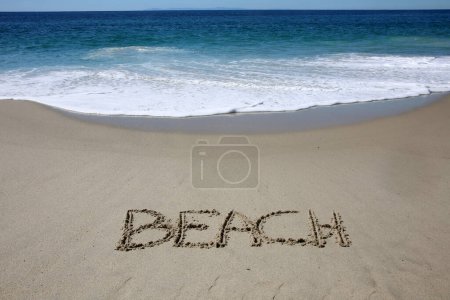 Téléchargez les photos : Beach written in the sand on the beach.  message handwritten on a smooth sand beach - en image libre de droit