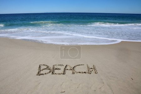 Téléchargez les photos : Beach written in the sand on the beach.  message handwritten on a smooth sand beach - en image libre de droit