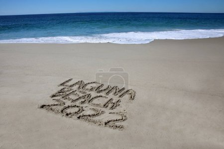 Téléchargez les photos : Laguna beach 2022 written in the sand on the beach.  message handwritten on a smooth sand beach - en image libre de droit