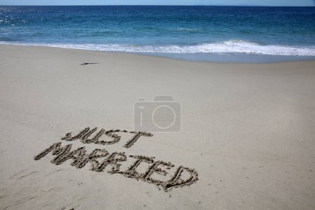 Téléchargez les photos : Just merried written in the sand on the beach.  message handwritten on a smooth sand beach - en image libre de droit