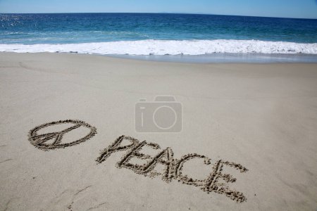 Téléchargez les photos : Peace written in the sand on the beach.  message handwritten on a smooth sand beach - en image libre de droit