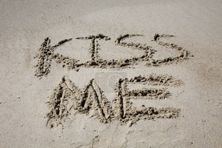 Téléchargez les photos : Kiss me written in the sand on the beach.  message handwritten on a smooth sand beach - en image libre de droit