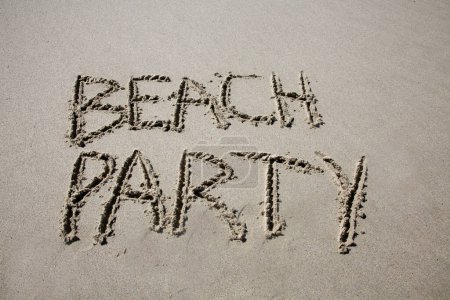 Téléchargez les photos : Beach party written in the sand on the beach.  message handwritten on a smooth sand beach - en image libre de droit