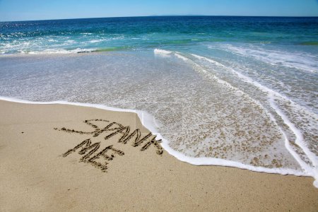 Téléchargez les photos : Spank me written in the sand on the beach.  message handwritten on a smooth sand beach - en image libre de droit