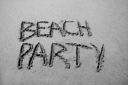 Foto de Beach  party written in the sand on the beach.  message handwritten on a smooth sand beach - Imagen libre de derechos