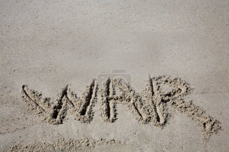 Foto de War written in the sand on the beach.  message handwritten on a smooth sand beach - Imagen libre de derechos