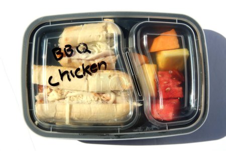Téléchargez les photos : BBQ Chicken Sandwich with Fresh Fruits. Restaurant Food to Go. Food Delivery. Lunch. Dinner. Packaged Food to go. Isolated on white. Room for text. Lunch Time. - en image libre de droit