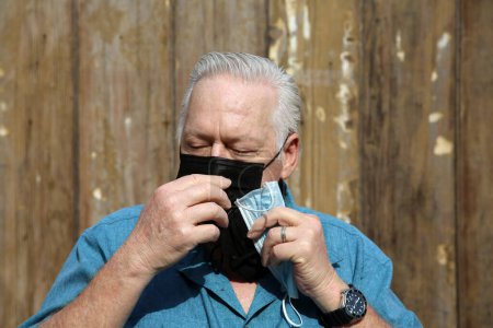Téléchargez les photos : Senior homme changer masque médical - en image libre de droit