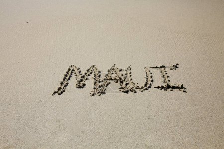 Téléchargez les photos : Maui written in the sand on the beach.  message handwritten on a smooth sand beach - en image libre de droit