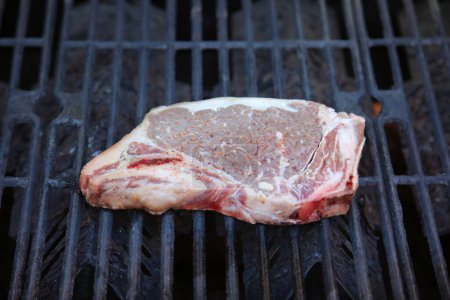 Photo for Steak. Beef Stake. Fresh raw beef steak. Raw Meat. Steak on the Barbecue. Barbecue grill. Grilling Meat on a BBQ grill. T-Bone steak. Cut of Beef. Grilled Meat. Porterhouse. Rib-eye. Top Sirloin. - Royalty Free Image