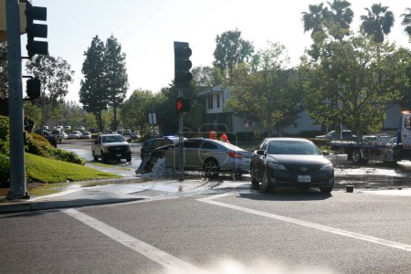 Photo for Lake Forest, California - USA - April 26, 2023: Major Car Accident. Car running over a Fire Hydrant and causing Flooding and a Water Hazard from a collision. Car Accident destroys a Fire Hydrant. - Royalty Free Image