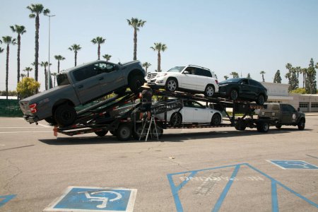 Photo for Buena Park, California - USA - April - 27-2023: Car Hauler. A new and used car hauler tractor and trailer with cars ready for delivery. New Car Transportation. Big rig industrial grade car hauler. - Royalty Free Image