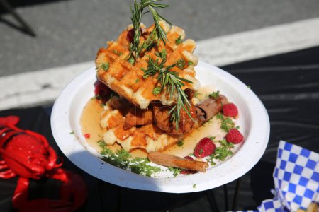 Photo for Chicken and Waffles. Deep Fried Chicken and Crispy Fresh Waffle with various fixing's on a plate. Exotic Food Truck Meal at a Street Fair or Public Market for anyone who is hungry and wants lunch. - Royalty Free Image