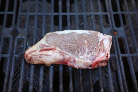 Photo for Steak. Beef Stake. Fresh raw beef steak. Raw Meat. Steak on the Barbecue. Barbecue grill. Grilling Meat on a BBQ grill. T-Bone steak. Cut of Beef. Grilled Meat. Porterhouse. Rib-eye. Top Sirloin. - Royalty Free Image