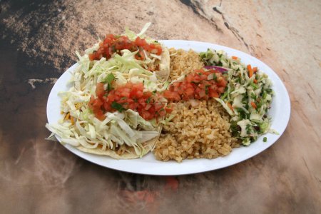 Photo for Fish Tacos. Crispy Fish Taco. Alaska Flounder with lightly seasoned breading on a corn tortilla with melted cheese, citrus slaw and cilantro sauce. Close up of fresh fish tacos with coleslaw and rice. - Royalty Free Image