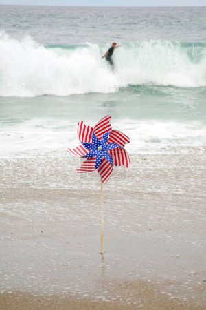 Foto de Bandera Americana. Una bandera americana Pin en la brisa en la playa. Bandera americana en la playa en la arena. - Imagen libre de derechos