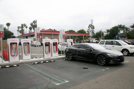 Foto de Irvine, California - Estados Unidos - 21 de junio de 2023: Tesla Electric Car Charging Station. Muchos coches de carga en una estación Tesla Supercharger. Las estaciones de supercargador permiten que los coches Tesla se carguen rápidamente. - Imagen libre de derechos