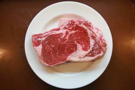 Téléchargez les photos : Un steak. Steak de boeuf. Viande rouge. Bifteck moyen juteux aux côtes de boeuf. Viande crue en gros plan - en image libre de droit