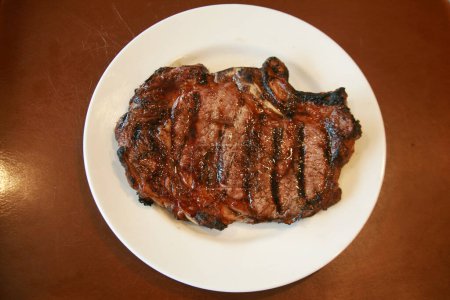 Photo for Steak. Beef Steak. Red Meat. Juicy medium Beef Rib Eye steak. Grilled Beef Steak on a white plate. Meat from the BBQ Grill. Grilled sirloin on a White Ceramic Plate. Lunch is served. Dinner Time. - Royalty Free Image