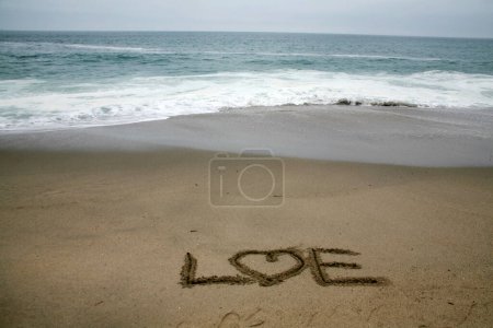 Photo for Love written in beach sand with the ocean as the background. - Royalty Free Image