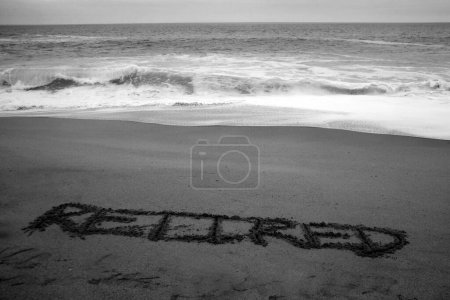 Foto de Jubilado escrito en arena de playa con el océano como fondo. - Imagen libre de derechos