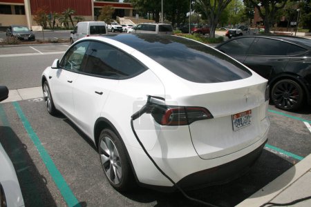 Foto de Long Beach - California - Estados Unidos - 19 de abril de 2023: Tesla Electric Car está siendo cargado con electricidad. Carga de coches en una estación Tesla Supercharger. Las estaciones de supercargador permiten recargar coches Tesla. - Imagen libre de derechos
