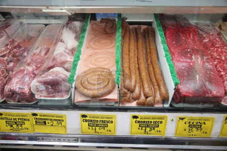 Photo for Meat Market. Fresh Cuts of Raw Meat in a Meat Market Refrigerated Window for sale. Cuts of Beef, Pork, Chicken, and more for sale. Fresh Meat. Steaks. Ground Beef. Pork Loin. Butchers Special Cut. - Royalty Free Image