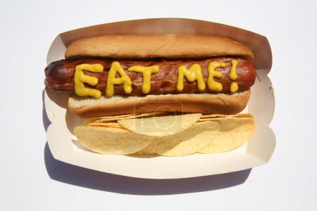 Foto de Hotdog con el texto escrito en mostaza amarilla. Perros calientes para el almuerzo. Aislado sobre blanco. Hotdog en un camión rojo. - Imagen libre de derechos