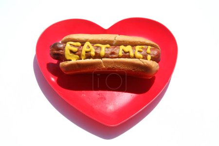 Téléchargez les photos : Hotdog avec le texte écrit en moutarde jaune. Hotdogs pour le déjeuner. Isolé sur blanc. Hotdog dans un camion rouge. - en image libre de droit