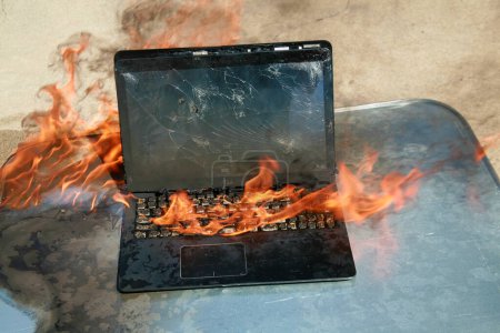 Photo for Burning laptop and keyboard. Laptop Computer on fire. Laptop burning in flames. Fire hazard. Losing valuable data. Computer Damage. Haunted laptop. Fire due to Evil. Computer in Hell. Halloween. - Royalty Free Image