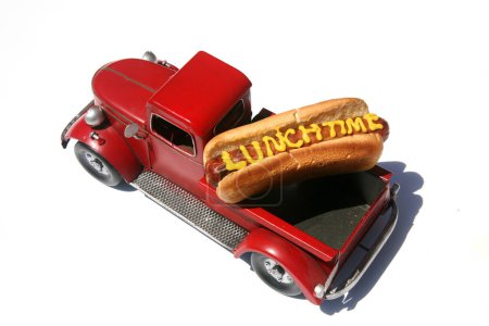 Photo for Hotdog with the words lunch time written in Yellow Mustard. Hotdogs for Lunch. Isolated on white. Hotdog in a red truck in its bun. - Royalty Free Image