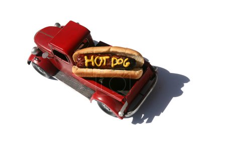Photo for Hotdog with the words Hot Dog written in Yellow Mustard. Hotdogs for Lunch. Isolated on white. Hotdog in a red truck in its bun. - Royalty Free Image