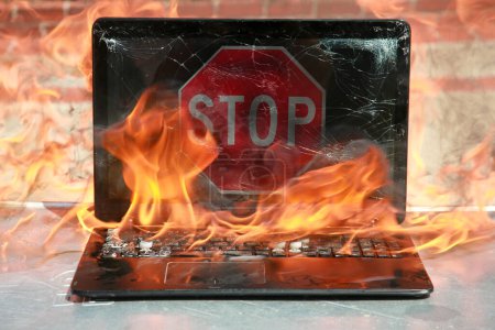 Burning laptop and keyboard, equipment fire due to faulty battery and wiring. Laptop Computer setting the world on fire. Laptop burning in flames. Fire hazard. Losing valuable data. Laptop Damage.