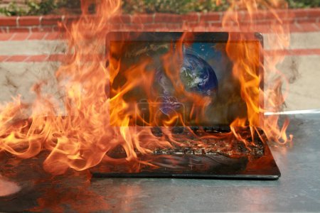 Photo for Burning laptop and keyboard, equipment fire due to faulty battery and wiring. Laptop Computer setting the world on fire. Laptop burning in flames. Fire hazard. Losing valuable data. Laptop Damage. - Royalty Free Image