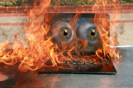 Photo for Burning laptop and keyboard, equipment fire due to faulty battery and wiring. Laptop Computer setting the world on fire. Laptop burning in flames. Fire hazard. Losing valuable data. Laptop Damage. - Royalty Free Image