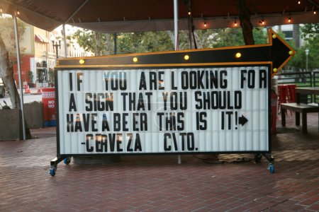 Foto de Santa Ana, California - Estados Unidos - 25 de julio de 2023: Señal de cerveza. Un cartel de la carpa con una declaración sobre la cerveza en un restaurante. Cerveza es lo que todo el mundo debería beber. Signo de cerveza. Signo publicitario. Humor. - Imagen libre de derechos
