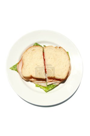 Foto de Sandwich casero con pavo ahumado, lechuga, tomate y queso en plato blanco aislado - Imagen libre de derechos