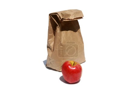 Téléchargez les photos : Sac à lunch en papier brun et pomme rouge isolés sur fond blanc - en image libre de droit