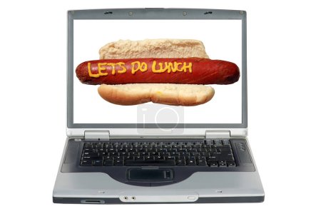 Foto de Ordenador portátil con un perro caliente con eslogan escrito en mostaza amarilla "Vamos a hacer el almuerzo" - Imagen libre de derechos
