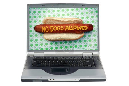 Téléchargez les photos : Ordinateur portable avec hot dog avec slogan écrit en moutarde jaune "pas de chiens autorisés" - en image libre de droit