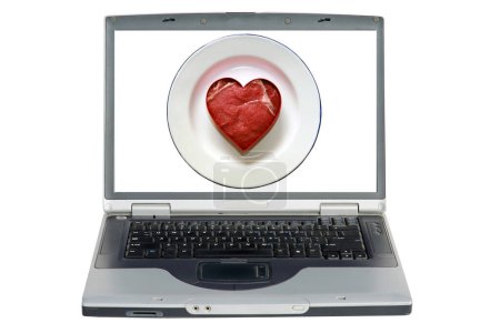 Photo for Isolated Laptop Computer with a Heart Shaped Steak. Fresh raw USDA Beef Steak cut into a Heart shape on a white plate - Royalty Free Image