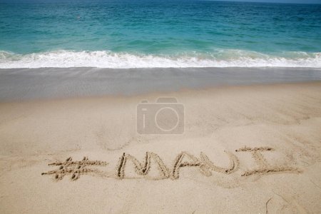 Foto de El nombre # Maui escrito en arena en la playa con el fondo del Océano Pacífico. - Imagen libre de derechos