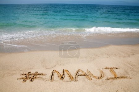 Foto de El nombre # Maui escrito en arena en la playa con el fondo del Océano Pacífico. - Imagen libre de derechos
