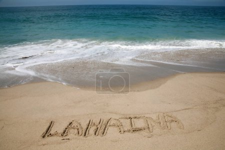 Photo for The name LAHAINA written in the sand on the beach with the Pacific Ocean background - Royalty Free Image