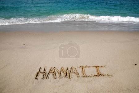 Téléchargez les photos : Le nom HAWAII écrit dans le sable à la plage d'Hawaï. - en image libre de droit